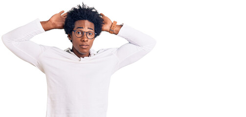 Handsome african american man with afro hair wearing casual clothes and glasses doing bunny ears...