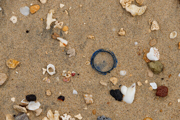 stones washed from the sea sand form beautiful patterns with a piece of green glass in the middle