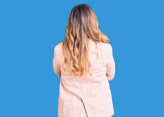 Young caucasian woman wearing business clothes standing backwards looking away with crossed arms