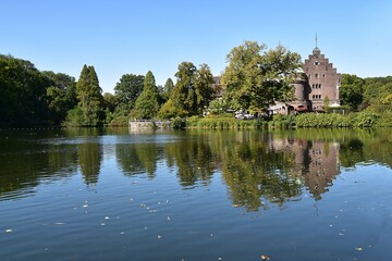 Fototapeta na wymiar Zamek w parku i odbicie w lustrze wody