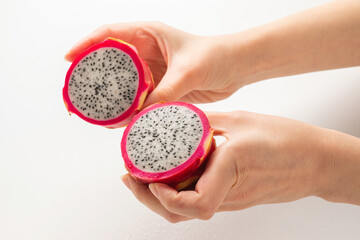 Sweet tasty dragon fruit or pitaya in woman hand isolated.