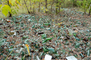 Lots of old broken bottles. A lot of broken glass. Waste bin made of glass bottles.