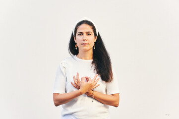 Portrait of woman holding gyan mudra next to heart, hand position from Kundalini yoga meditation...