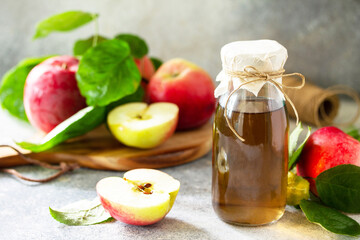 Apple vinegar. Healthy organic food. A bottle of apple cider vinegar on a light stone countertop.