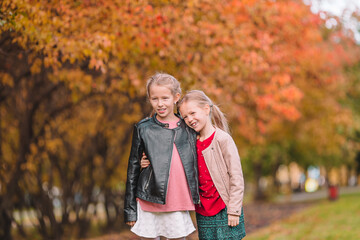 Little adorable girls outdoors at warm sunny autumn day