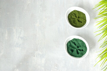 Chlorella and spirulina powder on a light background. A green superfood detox for a vegetarian diet. Healthy lifestyle concept. Copy space