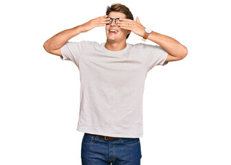 Fototapeta premium Handsome caucasian man wearing casual clothes and glasses covering eyes with hands smiling cheerful and funny. blind concept.