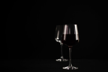 glasses with red wine on a dark background. photograph of wine in a low key.