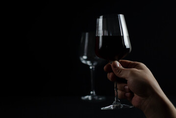 glasses with red wine on a dark background. photograph of wine in a low key.