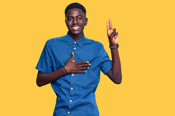 Young african american man wearing casual clothes smiling swearing with hand on chest and fingers...