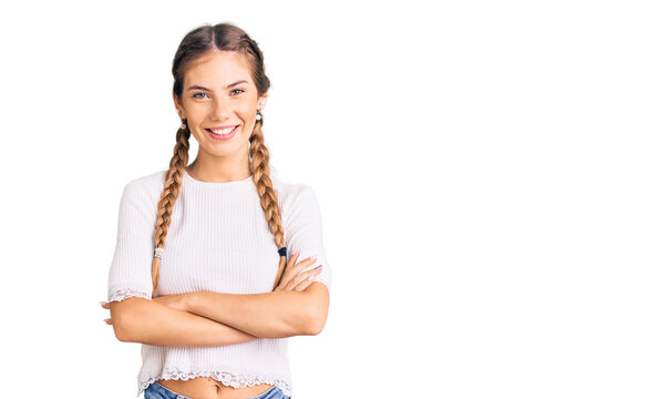 Beautiful caucasian woman with blonde hair wearing braids and white tshirt happy face smiling with crossed arms looking at the camera. positive person.
