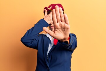 Young beautiful woman wearing stewardess uniform covering eyes with hands and doing stop gesture with sad and fear expression. embarrassed and negative concept.