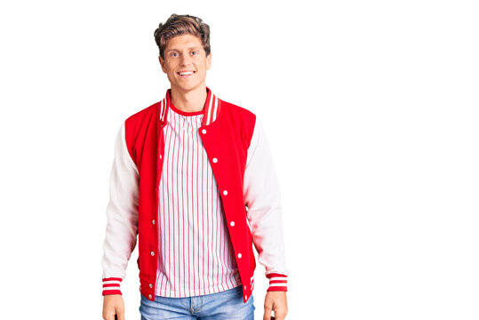 Young handsome man wearing baseball uniform with a happy and cool smile on face. lucky person.