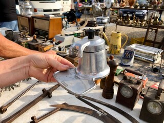Alicante, Spain - September, 2020: Hand holding old Italian espresso coffee maker on flea market in Guardamar de Segura town.
