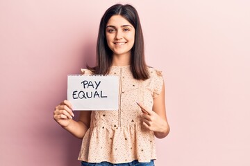 Young beautiful girl holding pay equal paper smiling happy pointing with hand and finger