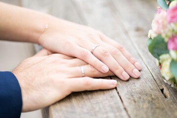 Marriage Symbolic Hands Together with Rings on Wooden Table