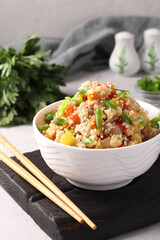 Fried rice with vegetables, garlic, ginger and green onion on grey background. Asian cuisine. Vegetarian food