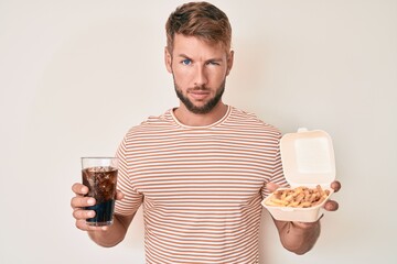 Young caucasian man eating fast food skeptic and nervous, frowning upset because of problem. negative person.