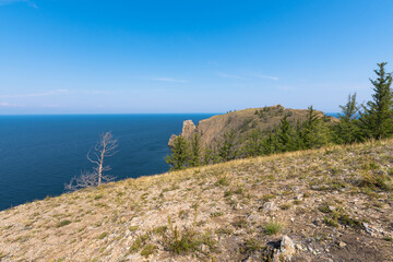 Cape Khoboy surrounded by the turquoise water of Lake Baikal is the northernmost point of Olkhon Island. Place of power in local beliefs.