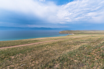 Picturesque sky over the Maloye More Strait. Federal highway on the steppe coast of Olkhon Island.