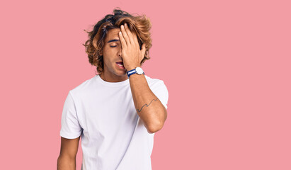 Young hispanic man wearing casual white tshirt yawning tired covering half face, eye and mouth with...