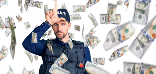 Young handsome man wearing police uniform making fun of people with fingers on forehead doing loser...