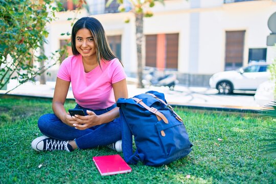 Young latin student girl smiling happy using smartphone at university campus.