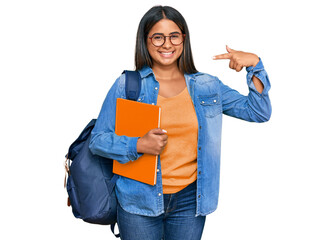 Young latin girl wearing student backpack and holding books smiling cheerful showing and pointing with fingers teeth and mouth. dental health concept.