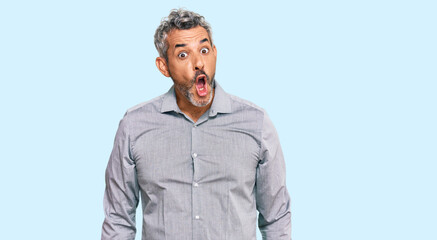 Middle age grey-haired man wearing casual clothes afraid and shocked with surprise expression, fear and excited face.