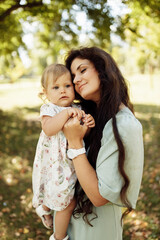 Portrait of amazing mother with cute little daughter walking in the forest. Family concept.