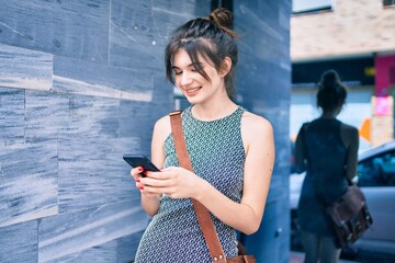 Young caucasian businesswoman smiling happy using smartphone at the city.
