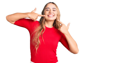 Young beautiful blonde woman wearing casual clothes smiling cheerful showing and pointing with fingers teeth and mouth. dental health concept.