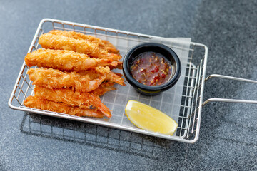 Breaded shrimps with chili sauce and slice of lemon served at the bar, finger food