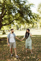 Fototapeta premium Lovely couple smiling in the garden. Wife and husband holding each other in the beautiful place. Happy marriage concept.