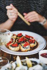 Girl eating baked susi maki with chopsticks at Japanese restaurant, selective focus. Japanese cuisine, fast food, seafood, fine dining concept