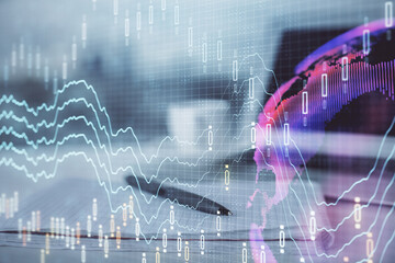 Double exposure of financial graph drawings and desk with open notebook background. Concept of forex market