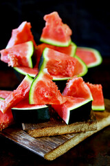 Lots of watermelon wedges on a wooden surface. Selective focus. Macro.