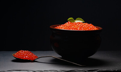 Red caviar in pot on stone plate.