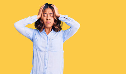 Young beautiful mixed race woman wearing casual business shirt suffering from headache desperate and stressed because pain and migraine. hands on head.