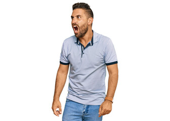 Fototapeta premium Handsome man with beard wearing casual clothes angry and mad screaming frustrated and furious, shouting with anger. rage and aggressive concept.