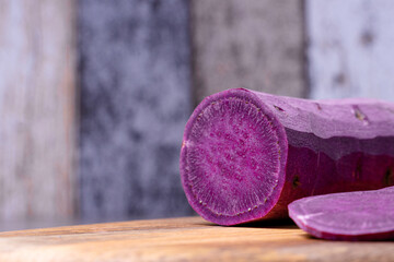 Foreground of the chopped sweet potato on the cutting board, background out of focus, healthy and ecological food.