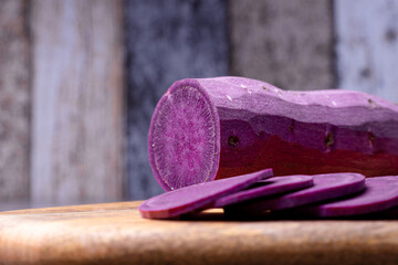 Foreground of the chopped sweet potato on the cutting board, background out of focus, healthy and...