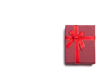 Red gift with a bow on a white background . Red bow. Bow on the gift. Gift wrapping. isolated background. Copy space. Article about gifts. New year and Christmas. Valentine's day.