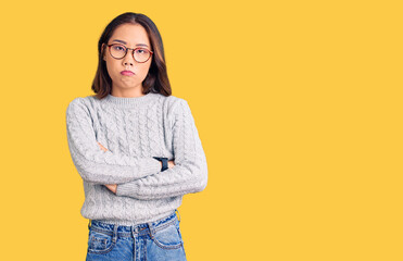 Young beautiful chinese girl wearing casual clothes skeptic and nervous, disapproving expression on face with crossed arms. negative person.