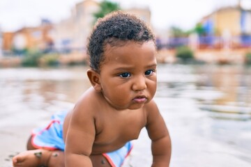 Adorable african american toddler sitting at the beach.