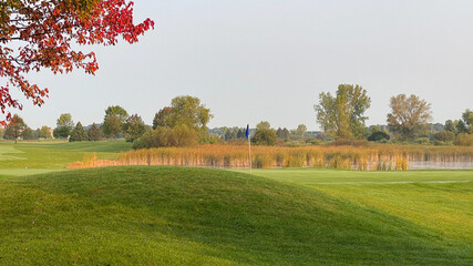golf course pond marsh late summer early autumn red leaves on trees