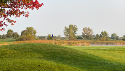 golf course pond marsh late summer early autumn red leaves on trees