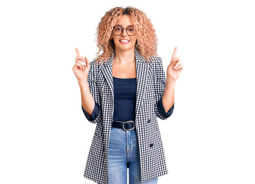 Young blonde woman with curly hair wearing business jacket and glasses smiling confident pointing with fingers to different directions. copy space for advertisement