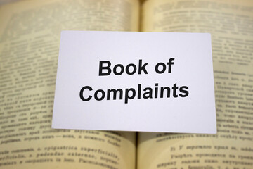 Book of complaints written in white note on open books