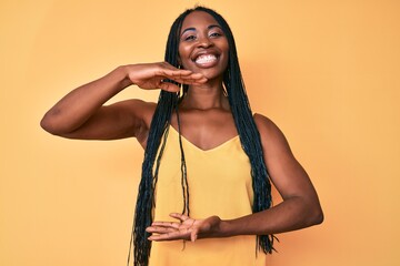 African american woman with braids wearing casual clothes gesturing with hands showing big and large size sign, measure symbol. smiling looking at the camera. measuring concept.